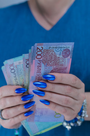 Female hands holding paper bills Belarusian rubles