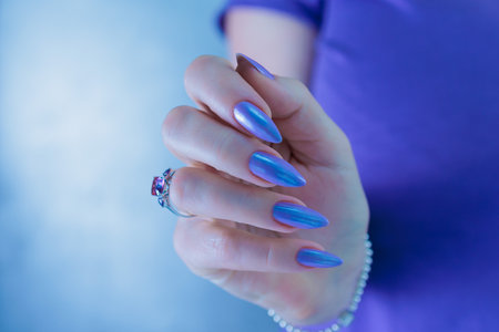 Woman's beautiful hand with long nails and dark blue manicureの写真素材