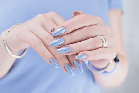 Female hand with long nails and a lilac blue nail polish