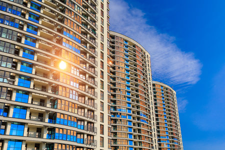 Modern buildings, walls and windows, reflections and sun rays. City view on a sunny day.の写真素材