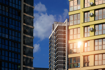 Modern buildings, walls and windows, reflections and sun rays. City view on a sunny day.の写真素材