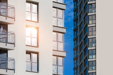 Modern buildings, walls and windows, reflections and sun rays. City view on a sunny day.の写真素材