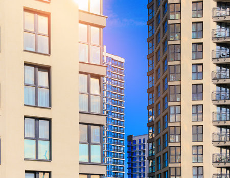 Modern buildings, walls and windows, reflections and sun rays. City view on a sunny day.の写真素材