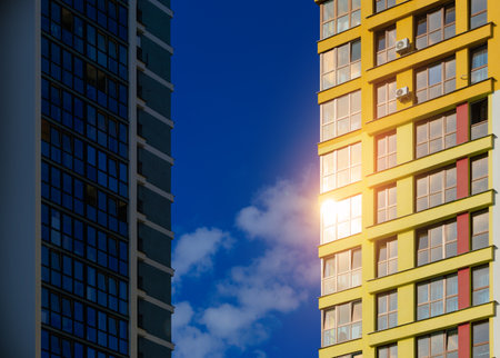 Modern buildings, walls and windows, reflections and sun rays. City view on a sunny day.の写真素材