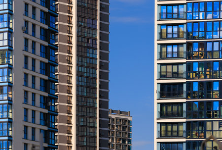 City view on a sunny day. Modern buildings, walls and windows.の写真素材