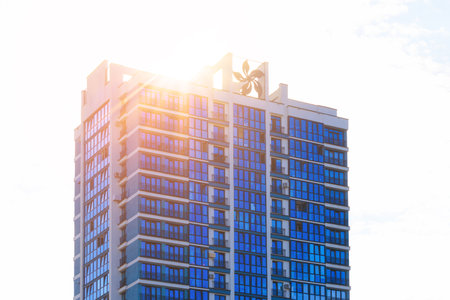Modern buildings, walls and windows, reflections and sun rays. City view on a sunny day.の写真素材