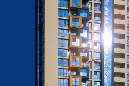 Modern buildings, walls and windows, reflections and sun rays. City view on a sunny day.の写真素材