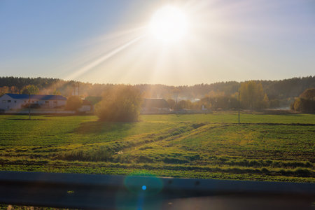 Roadside on a sunny day. View of the landscape and bright sun glare. View from the car window.の写真素材