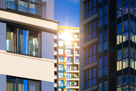 Modern buildings, walls and windows, reflections and sun rays. City view on a sunny day.の写真素材