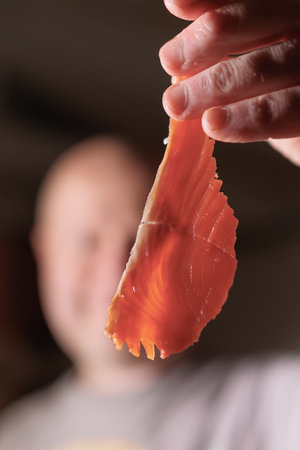 Male hands cutting red salmon fish