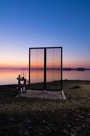Decorative elements for festive events, photo zone with flowers and candles, glass window or doors. Orange and blue sky at sunset in the evening and night.の写真素材