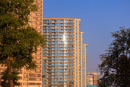 Modern buildings, walls and windows, reflections and sun rays. City view on a sunny day.の写真素材