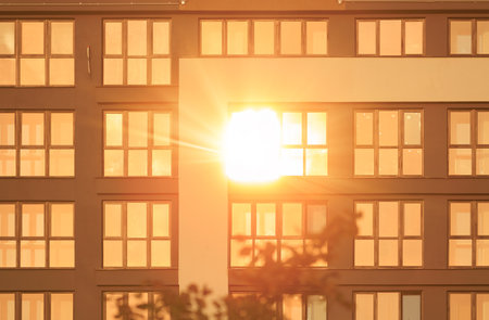 Modern buildings, walls and windows, reflections and sun rays. City view on a sunny day.の写真素材