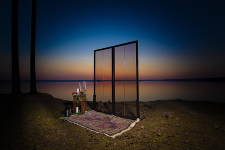Decorative elements for festive events, photo zone with flowers and candles, glass window or doors. Orange and blue sky at sunset in the evening and night.の写真素材