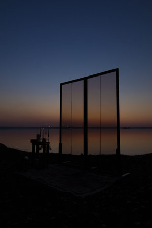 Decorative elements for festive events, photo zone with flowers and candles, glass window or doors. Orange and blue sky at sunset in the evening and night.の写真素材