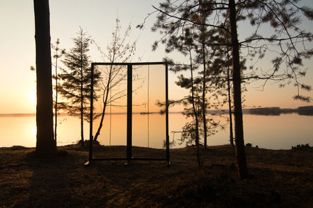 The image features a glass window or door in a natural setting with an orange and blue sky at sunset in the evening and night.の写真素材
