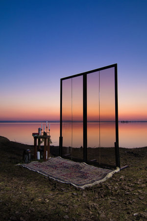 Decorative elements for festive events, photo zone with flowers and candles, glass window or doors. Orange and blue sky at sunset in the evening and night.の写真素材