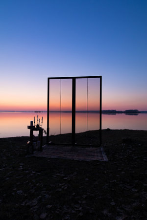 Decorative elements for festive events, photo zone with flowers and candles, glass window or doors. Orange and blue sky at sunset in the evening and night.の写真素材