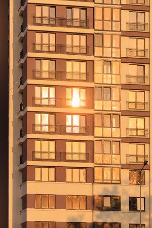 Modern buildings, walls and windows, reflections and sun rays. City view on a sunny day.の写真素材