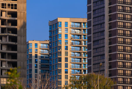 Modern buildings, walls and windows, reflections and sun rays. City view on a sunny day.の写真素材