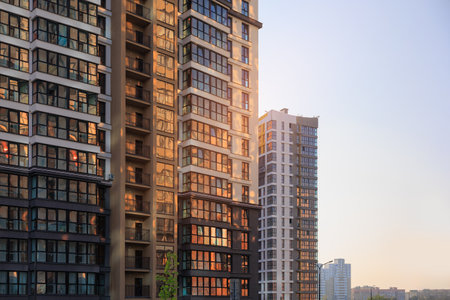 Modern buildings, walls and windows, reflections and sun rays. City view on a sunny day.の写真素材