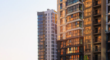 Modern buildings, walls and windows, reflections and sun rays. City view on a sunny day.の写真素材