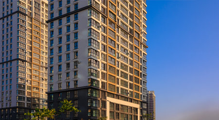 Modern buildings, walls and windows, reflections and sun rays. City view on a sunny day.の写真素材