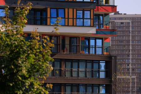 Modern buildings, walls and windows, reflections and sun rays. City view on a sunny day.