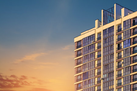 Modern buildings, walls and windows, reflections and sun rays. City view on a sunny day.
