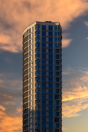 Modern buildings, walls and windows, reflections and sun rays. City view on a sunny day.