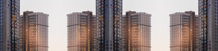 Modern buildings, walls and windows, reflections and sun rays. City view on a sunny day.