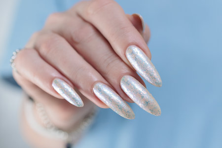 beautiful female hands with long nails light white manicureの写真素材