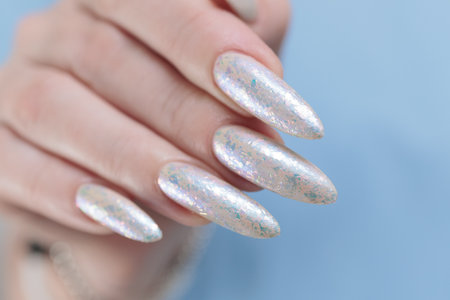 beautiful female hands with long nails light white manicureの写真素材