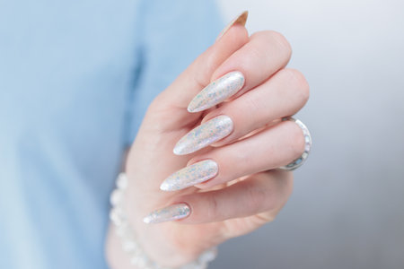 beautiful female hands with long nails light white manicureの写真素材