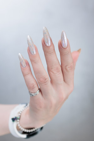 beautiful female hands with long nails light white manicureの写真素材
