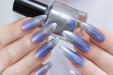 Female hand with long nails and bright light blue and silver manicureの写真素材