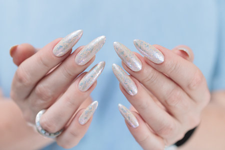 beautiful female hands with long nails light white manicureの写真素材