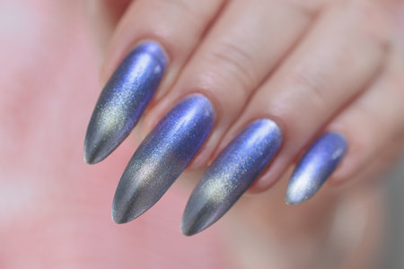 Female hand with long nails and bright light blue and silver manicureの写真素材