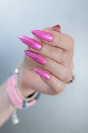 beautiful female hands with long nails and bright neon pink red nail polishの写真素材