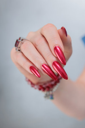 Female hands with long nails and red nail polishの写真素材