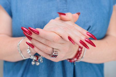 Female hands with long nails and red nail polishの写真素材