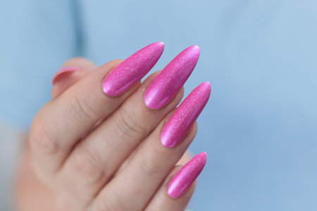 beautiful female hands with long nails and bright neon pink red nail polishの写真素材