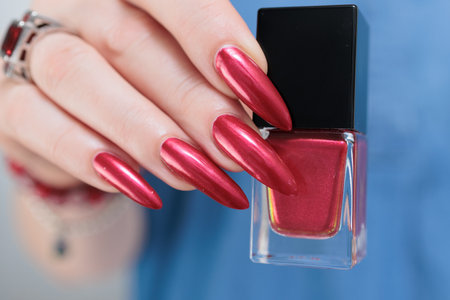 Female hand with long nails and a bright red manicureの写真素材