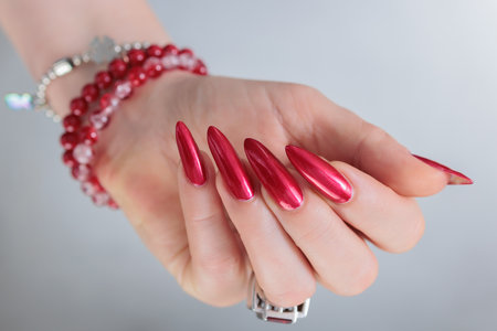 Female hands with long nails and red nail polishの写真素材