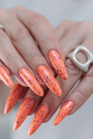 Hand with long nails and light orange neon manicureの写真素材