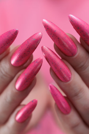 beautiful female hands with long nails and bright neon pink red nail polishの写真素材