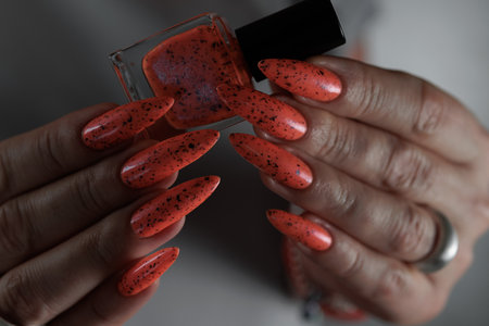 Woman hand with long nails and light orange neon manicureの写真素材