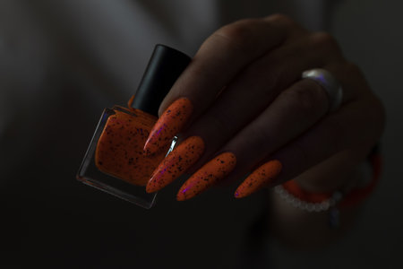 Woman hand with long nails and light orange neon manicureの写真素材