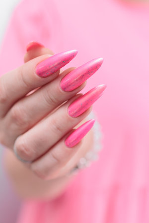beautiful female hands with long nails and bright neon pink red nail polishの写真素材