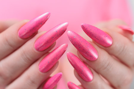 beautiful female hands with long nails and bright neon pink red nail polishの写真素材